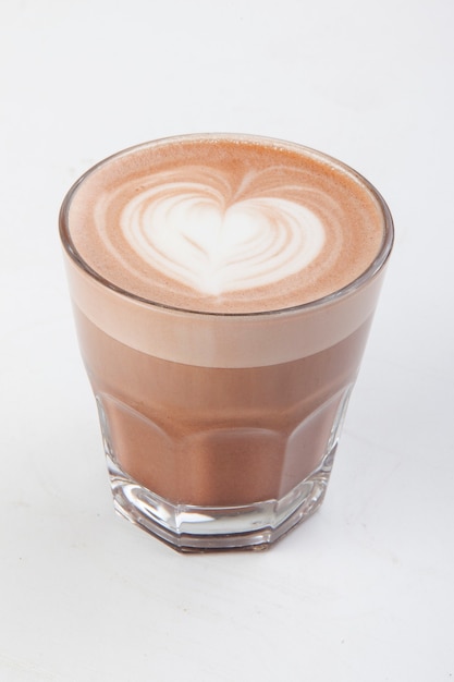 Zdjęcie gorąca latte z dekoracją w przezroczystym kubku na białym tle
