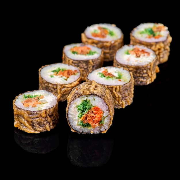 Gorące rolki sushi w tempurze z twarogiem na czarnym tle