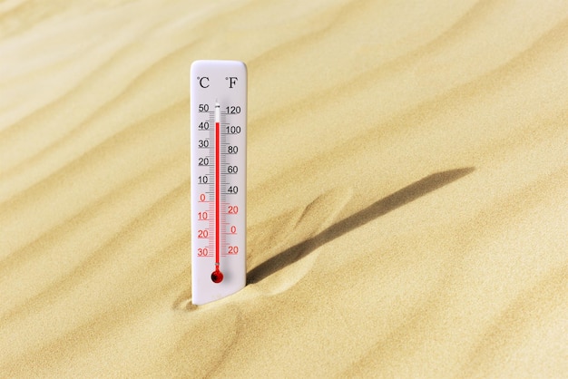 Gorący letni dzień termometr w skali Celsjusza i Fahrenheita w piasku Temperatura otoczenia plus 44