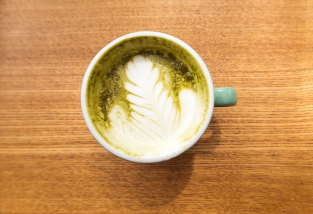 Gorący matcha zielonej herbaty latte na drewnianym tle, odgórny widok.