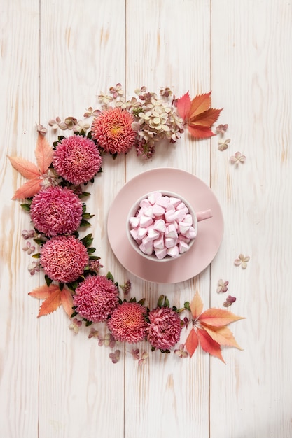 Gorący Napój Z Różowym Marshmallow W Różowej Filiżance Otaczającej Kwiecistym Wzorem Różowi Kwiaty I Liście
