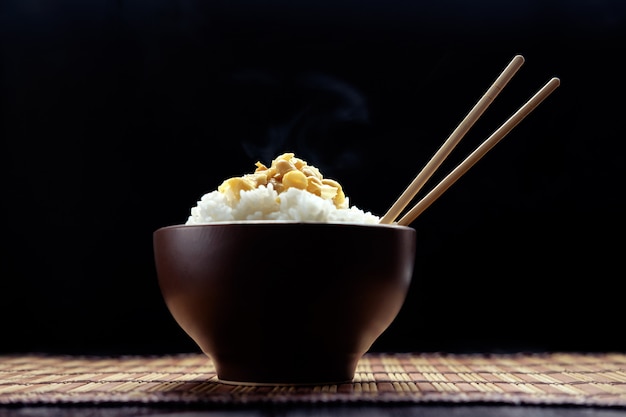 Gorący ryż z natto w brązowej misce z pałeczkami w stylu japońskim