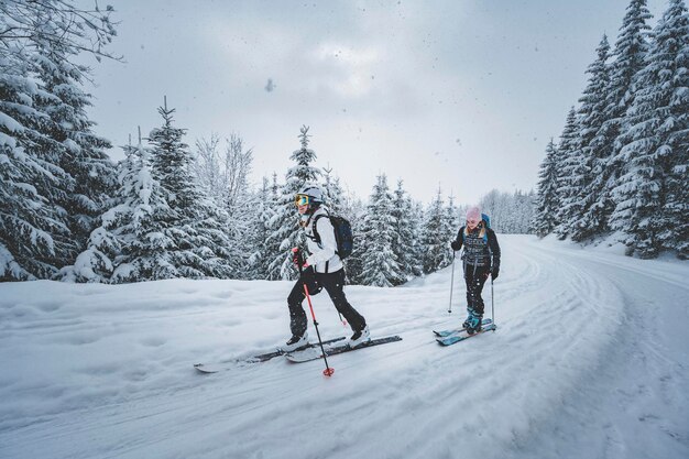 Góral backcountry ski walking skialpinista w górach Skialpinizm w alpejskim krajobrazie z ośnieżonymi drzewami Przygoda sporty zimowe