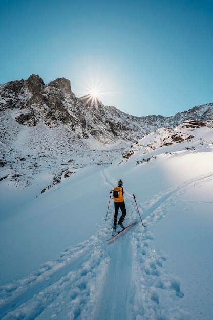 Góral backcountry ski walking skialpinista w górach Skialpinizm w alpejskim krajobrazie z ośnieżonymi drzewami Przygoda sporty zimowe