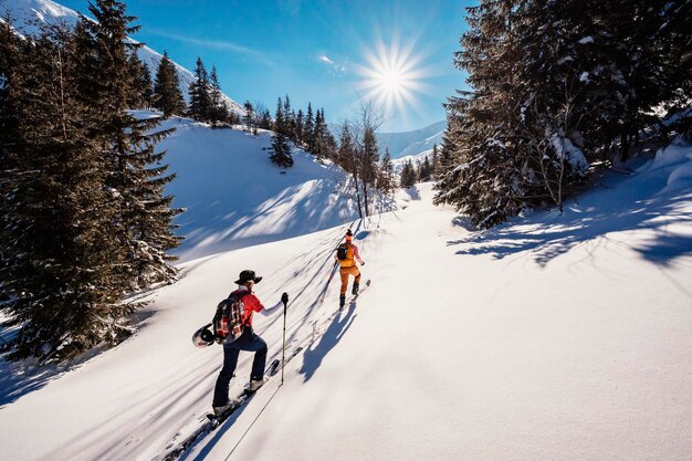 Góral backcountry ski walking skialpinista w górach Skialpinizm w alpejskim krajobrazie z ośnieżonymi drzewami Przygoda sporty zimowe