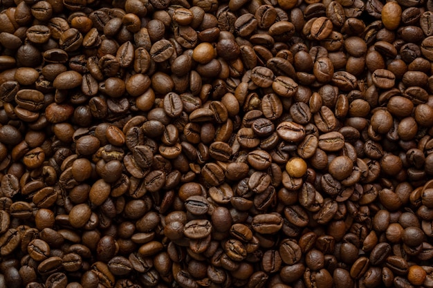 Zdjęcie górne zdjęcie ziaren kawy, na którym światło pada na nie z boku, aby podkreślić ich teksturę i cienie