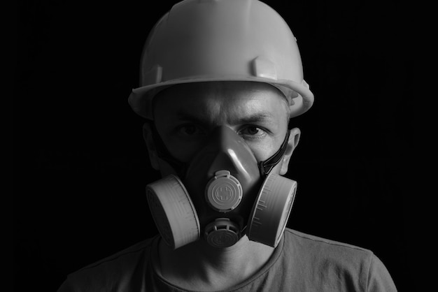 Górnik w kasku i respirator na czarno-białym zdjęciu.Przemysł węglowy, bezpieczeństwo i ochrona pracy.