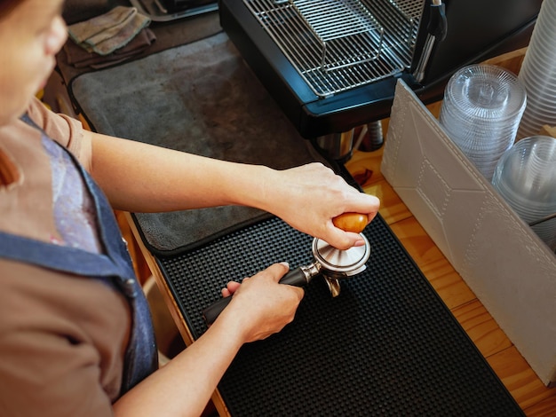Zdjęcie górny widok baristy trzymającego filtra i kawiarza robiącego kawę espresso w kawiarni