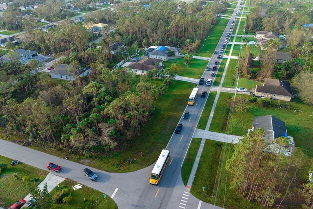 Zdjęcie górny widok klasycznego amerykańskiego żółtego autobusu szkolnego odbierającego dzieci na ulicy wiejskiej, zatrzymujący się na lekcjach wczesnym rankiem transport publiczny w stanach zjednoczonych