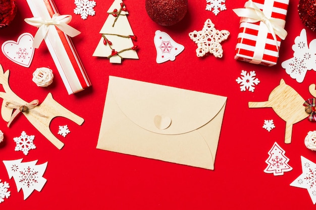 Zdjęcie górny widok koperty na czerwonym tle dekoracje noworoczne koncepcja świąt bożego narodzenia