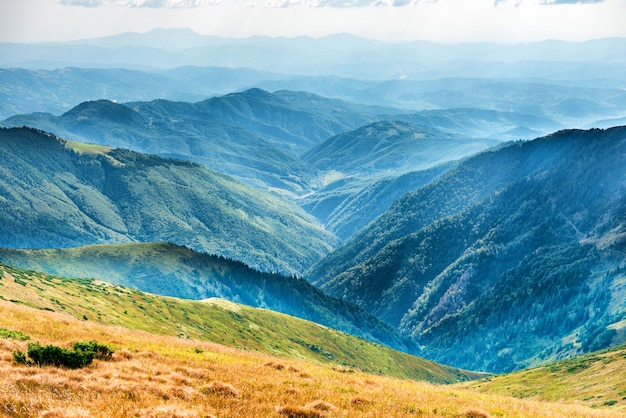 Górski krajobraz, dolina ze szczytami i błękitnymi wzgórzami