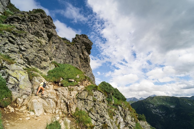 Górski krajobraz, na którym dziewczyna wspina się w Tatrach. Zdjęcie wysokiej jakości