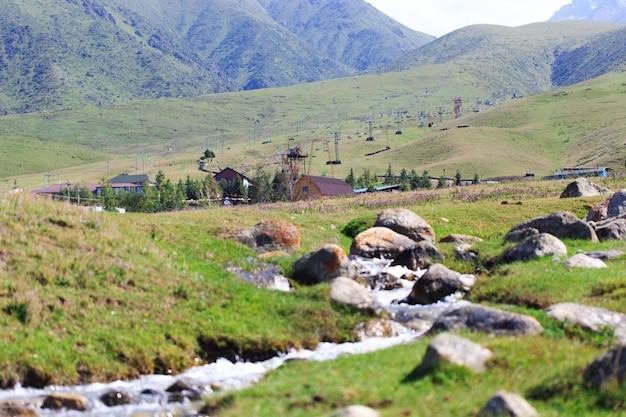 Górski potok na tle wiejskich domów Letni krajobraz górski Kirgistan