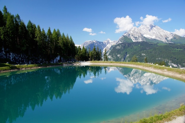 Górskie jezioro Berchtesgaden z odbijającą się górą i chmurami w czystej, błękitnej wodzie