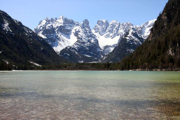 Górskie jezioro z zaśnieżonymi górami, włochy dolomity.
