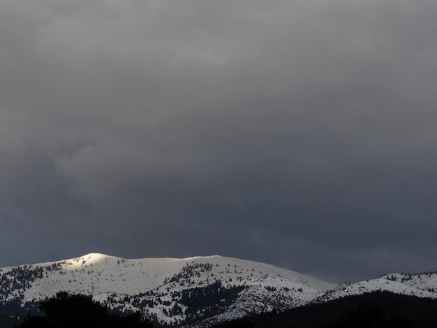 Góry i las ze śniegiem na tle chmur na wyspie Evia Eubea w Grecji