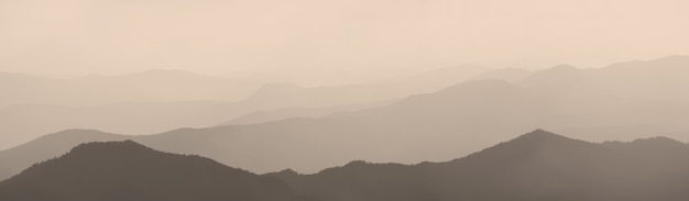 Zdjęcie góry i wzgórza w porannej mgle, panoramiczny widok, sepia