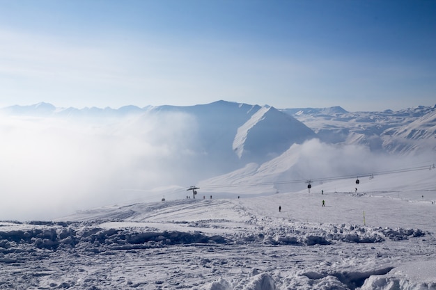 Góry Kaukazu wystają ponad chmury, oświetlone słońcem po wschodzie słońca. Niesamowity widok z góry Kazbek, Georgia. Koncepcja motywacji do podróży.