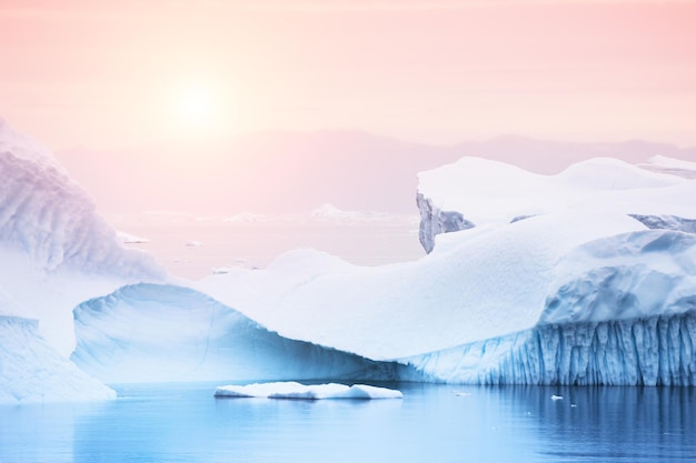 Góry lodowe na brzegu Oceanu Atlantyckiego o zachodzie słońca, zachodnia Grenlandia