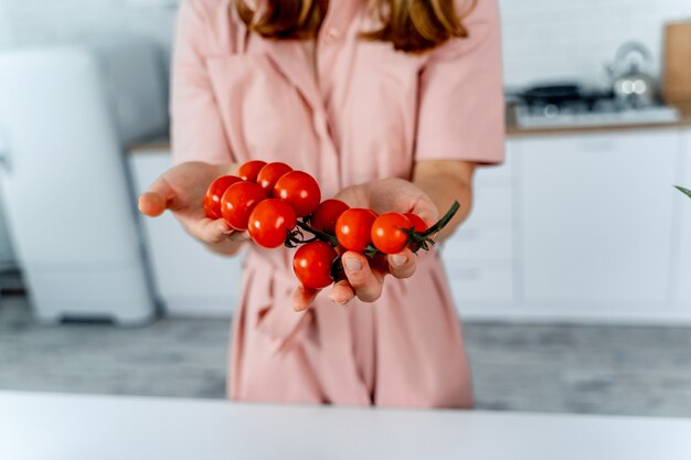 Gospodyni trzyma w rękach dojrzałe pomidorki koktajlowe