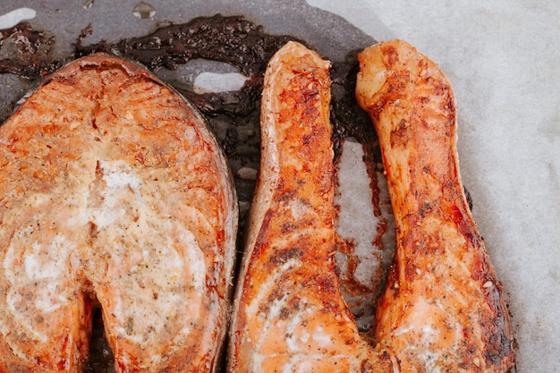 Gotowane steki z łososia na zbliżenie blachy do pieczenia. Steki z czerwonej ryby smażonej. Kawałki pieczonego łososia
