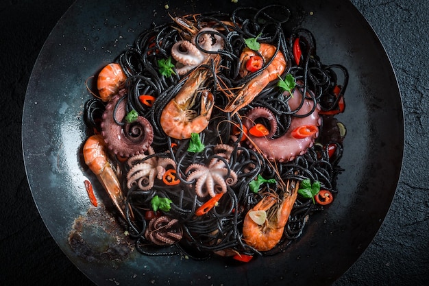 Gotowanie czarnego spaghetti z owocami morza z krewetek tygrysich ośmiornic