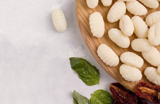 Gotowanie gnocchi na drewnianej desce. Przestrzeń na szare tło