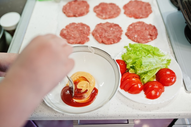 Gotowanie hamburgerów w domowej kuchni podczas kwarantanny.