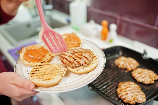 Gotowanie hamburgerów w domowej kuchni podczas kwarantanny.