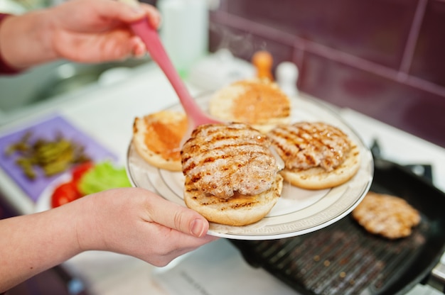 Gotowanie hamburgerów w domowej kuchni podczas kwarantanny.