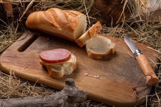 Gotowanie kanapek na desce do cięcia Baguette i kiełbaska Nóż kuchenny na desce Górny widok pod kątem