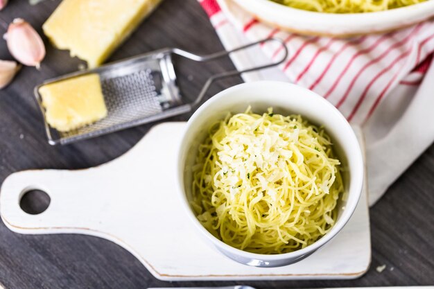 Gotowanie makaronu ekologicznego z ziołami czosnkowymi i parmezanem.