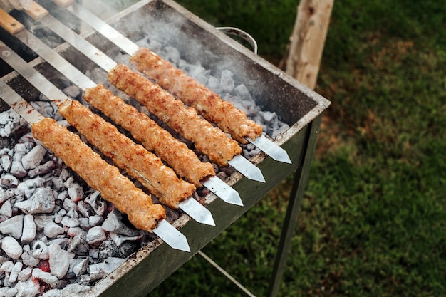 Zdjęcie gotowanie mięsa kebabowego z szaszłykami na grillu.