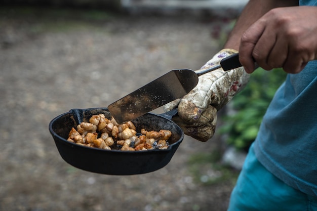 Gotowanie na grillu w żeliwnych naczyniach na świeżym powietrzu Ziemskie ziemniaki z smalcem