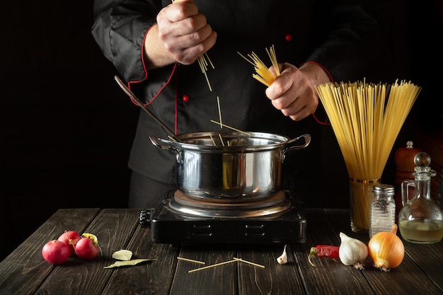Gotowanie pysznej zupy na lunch Środowisko pracy w kuchni Szef kuchni gotujący spaghetti w garnku