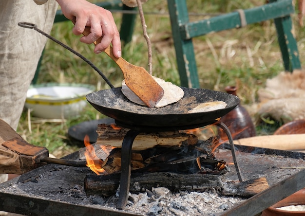 Gotowanie starożytnych tortilli zbożowych na patelni na drewnie