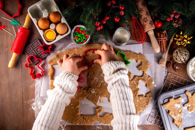 Gotowanie świątecznych ciasteczek rodzinne tło Matka i córka ręce widok z góry na przytulnym drewnianym tle robią ciasteczka imbirowe z cięciami do ciasteczek z noworoczną ozdobą świąteczną