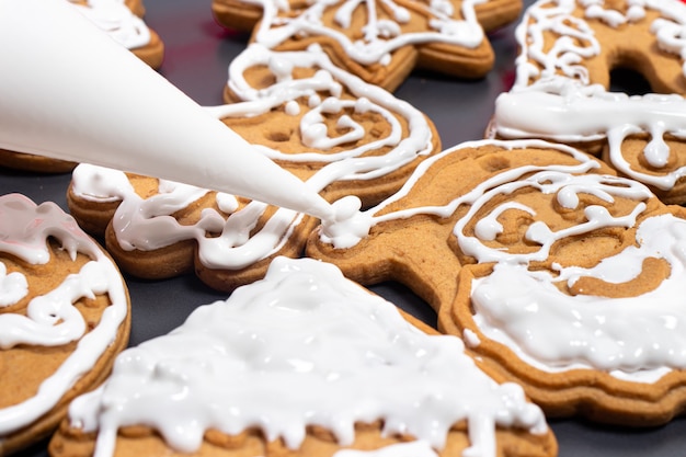 Zdjęcie gotowanie świątecznych ciasteczek świątecznych - nakładanie kremu na postać świętego mikołaja.