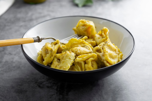 Gotujący tortellini na talerzu, zamykają w górę makaronu, włoski jedzenie.