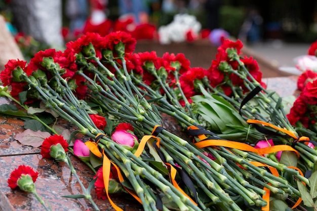 Zdjęcie goździki i wstążka świętego jerzego na tle pomnika