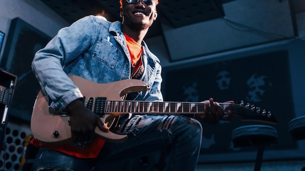 Gra na gitarze Młody afroamerykański wykonawca podczas próby w studiu nagraniowym