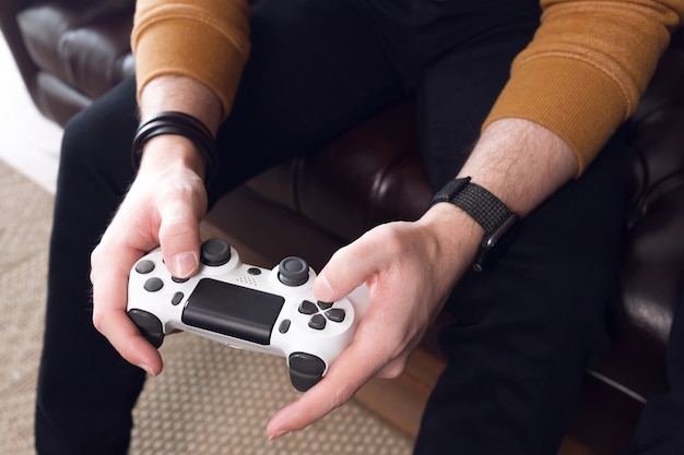 Zdjęcie gra na konsolę do gier, męskie dłonie trzymają joystick, aby grać w konsolę do gier. wysokiej jakości zdjęcie