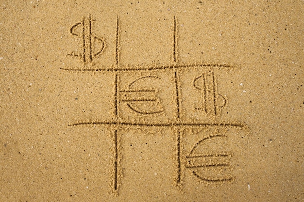 Gra Tactactoe z graniem w symbole euro i dolara na piasku