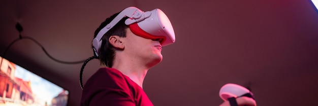 Gra Vr i gra dla graczy w wirtualnej rzeczywistości, grająca w futurystyczną symulacyjną strzelankę wideo w okularach 3D i joystickach w pokoju rozrywki vr z innowacyjną technologią i neonowym banerem