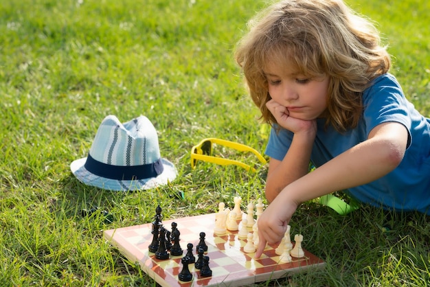 Gra w szachy dla dzieci Dziecko gra w szachy na świeżym powietrzu w parku