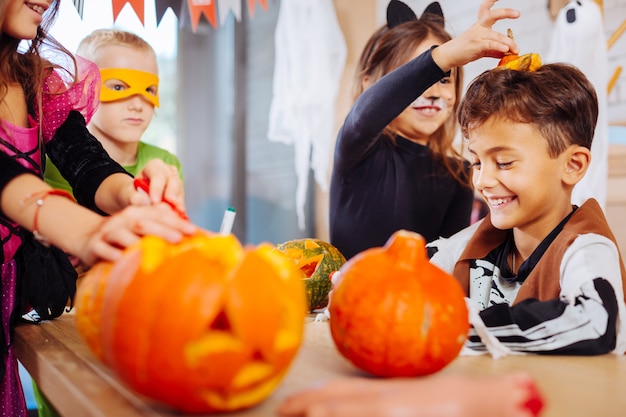 Gra Z Bratem. śliczna Młodsza Siostra Ubrana W Kostium Kota Na Halloween Bawi Się Z Uroczym Przystojnym Bratem