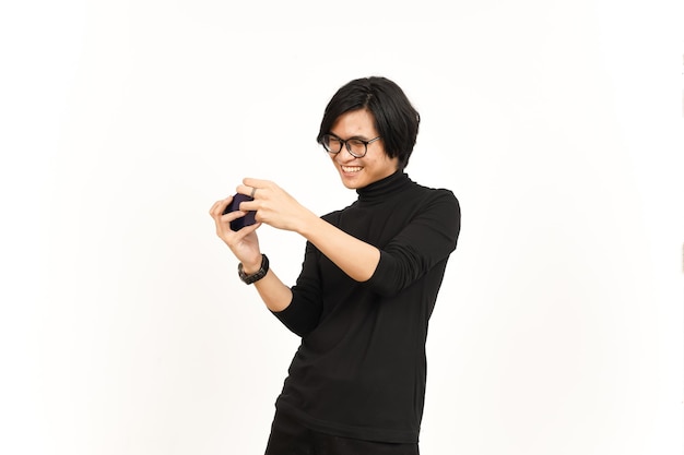 Grać w grę mobilną na smartfonie przystojny azjatycki mężczyzna na białym tle