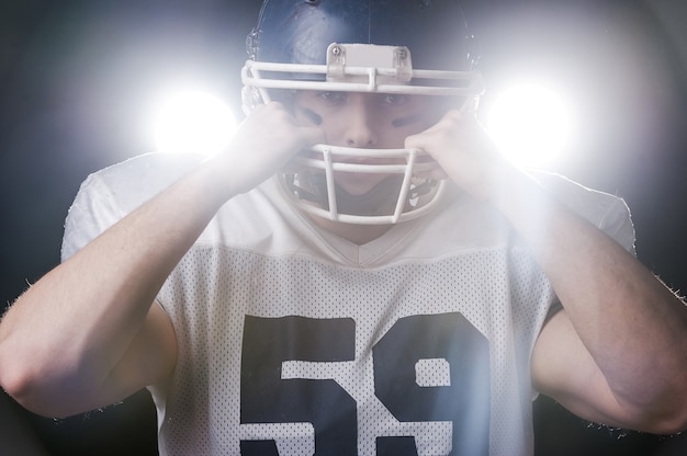 Zdjęcie gracz futbolu amerykańskiego stojący na podświetlanym tle