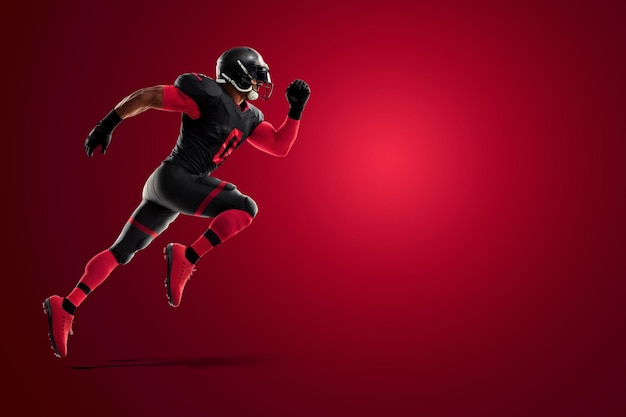 Gracz futbolu amerykańskiego w czerwonym i czarnym mundurze w pozie biegowej na czerwonym tle szablon plakatu reklamowego futbolu amerykańskiego pusty sport ilustracja 3D renderowanie 3D