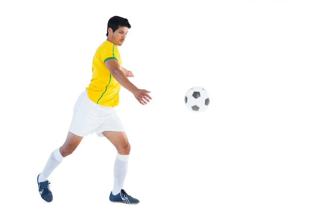 Gracz futbolu w żółtej kopanie piłce